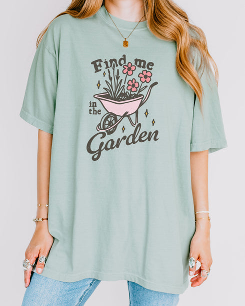 Model wearing bay color shirt with 'Find Me In The Garden' graphic design